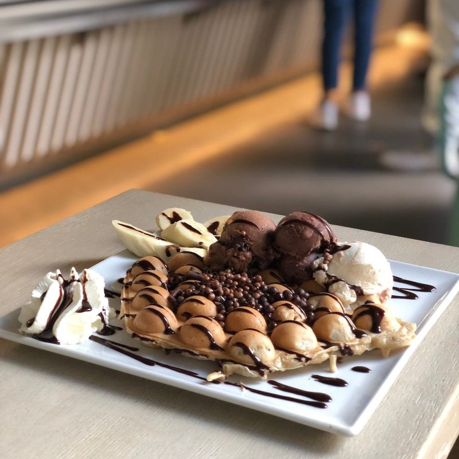 Bubble Waffle mit Banane, Schokoladeneis und Schokosauce auf dem Teller